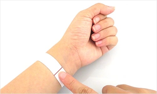 A photo of cut paper wrapped around the wrist