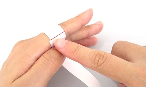 A photo of cut paper wrapped around a finger